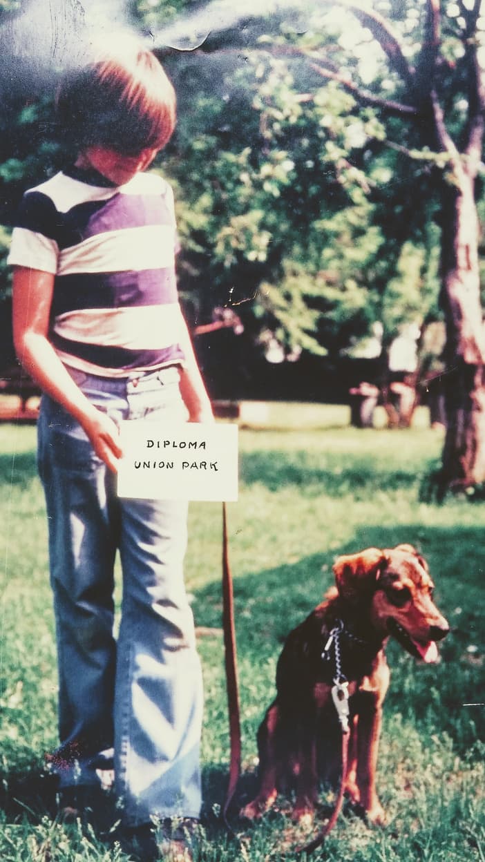 Eric Letendre as a boy holding a diploma beside his first dog, Union Park